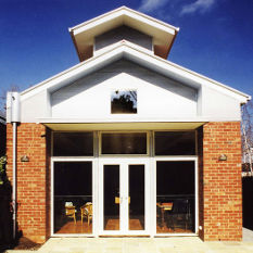 wide eaves protect the windows of this well-proportioned house on a long narrow block