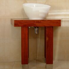 a sculptural bathroom with custom detailed redgum, chrome and stainless steel